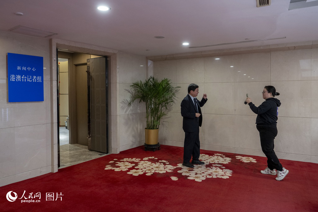 2月27日,媒体记者在全国两会新闻中心采访拍摄。人民网记者 翁奇羽摄